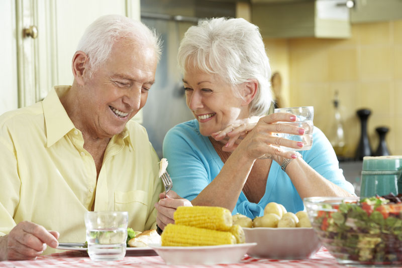 Dental Implant Patients Smiling Together While Eating Dinner