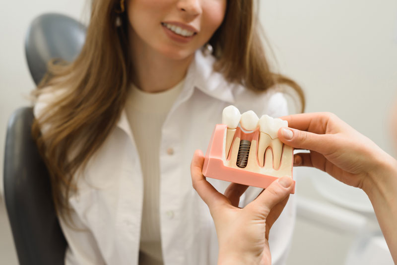 Dental Patient Getting Shown A Dental Implant Model During Her Consultation in Oakbrook Terrace, IL