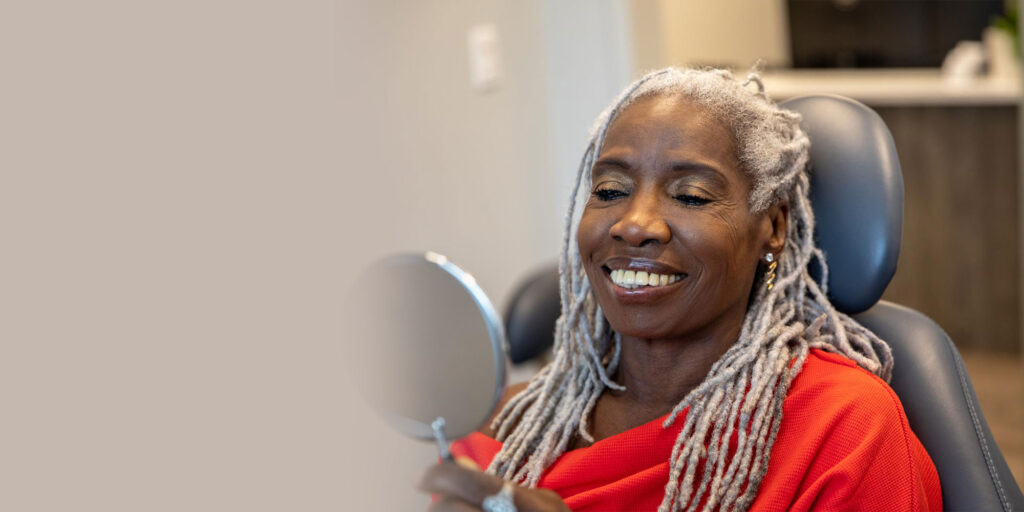 dental implant patient smiling in mirror